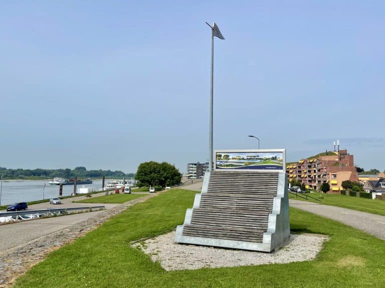 Uitzicht op 't Gelders Eiland met monument en rivier, zonnige dag.