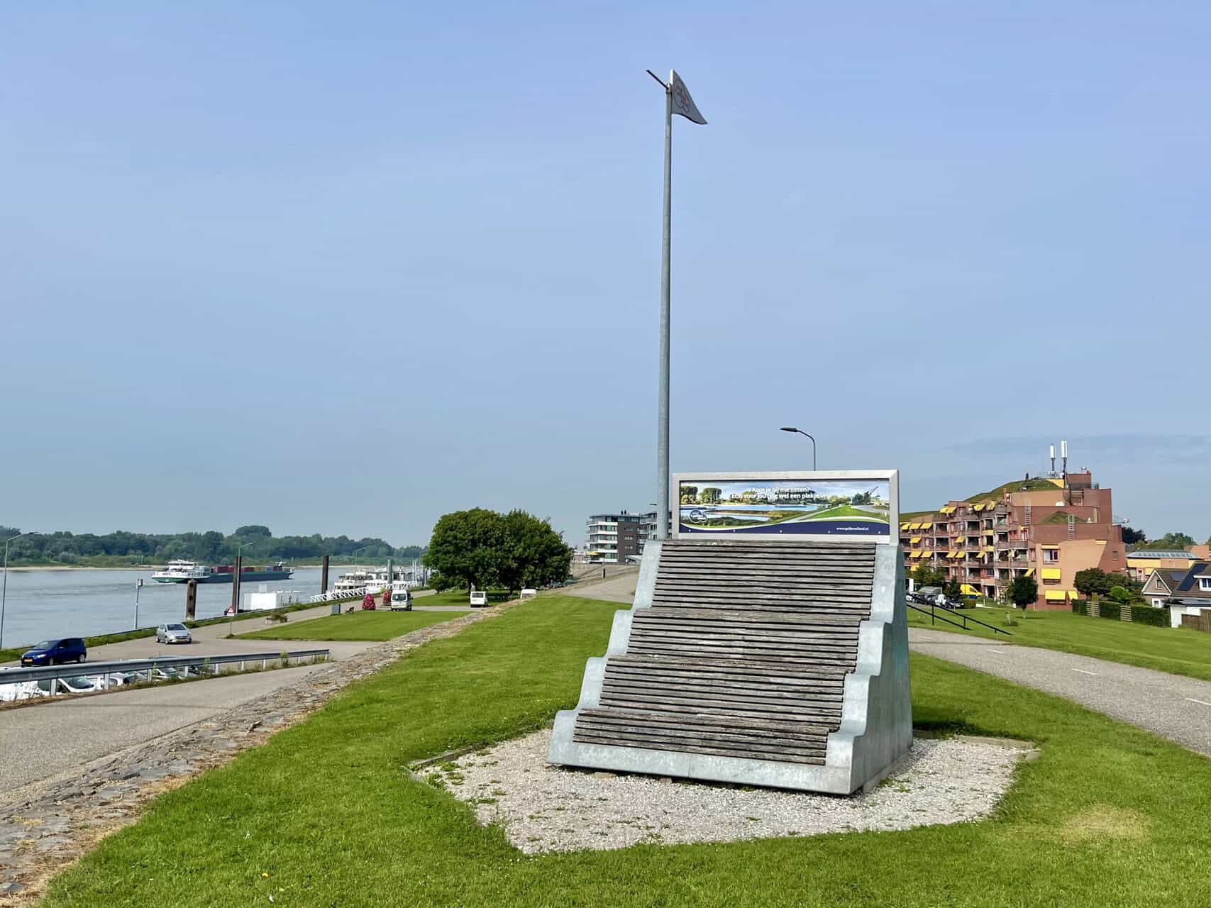 Uitzicht op 't Gelders Eiland met monument en rivier, zonnige dag.