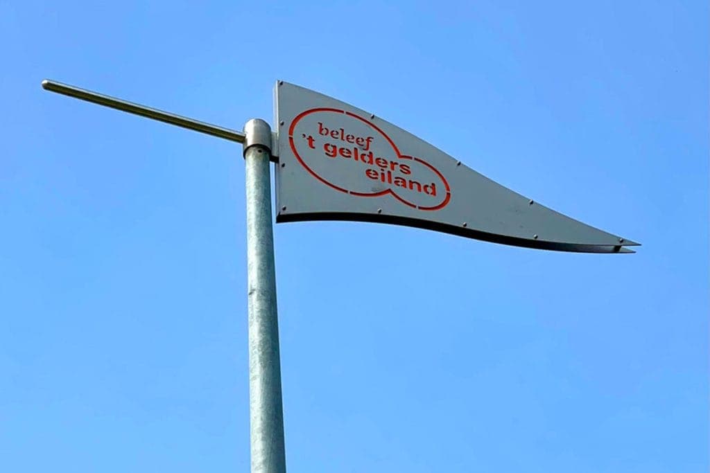 Vlag van 't Gelders Eiland tegen een heldere blauwe hemel.