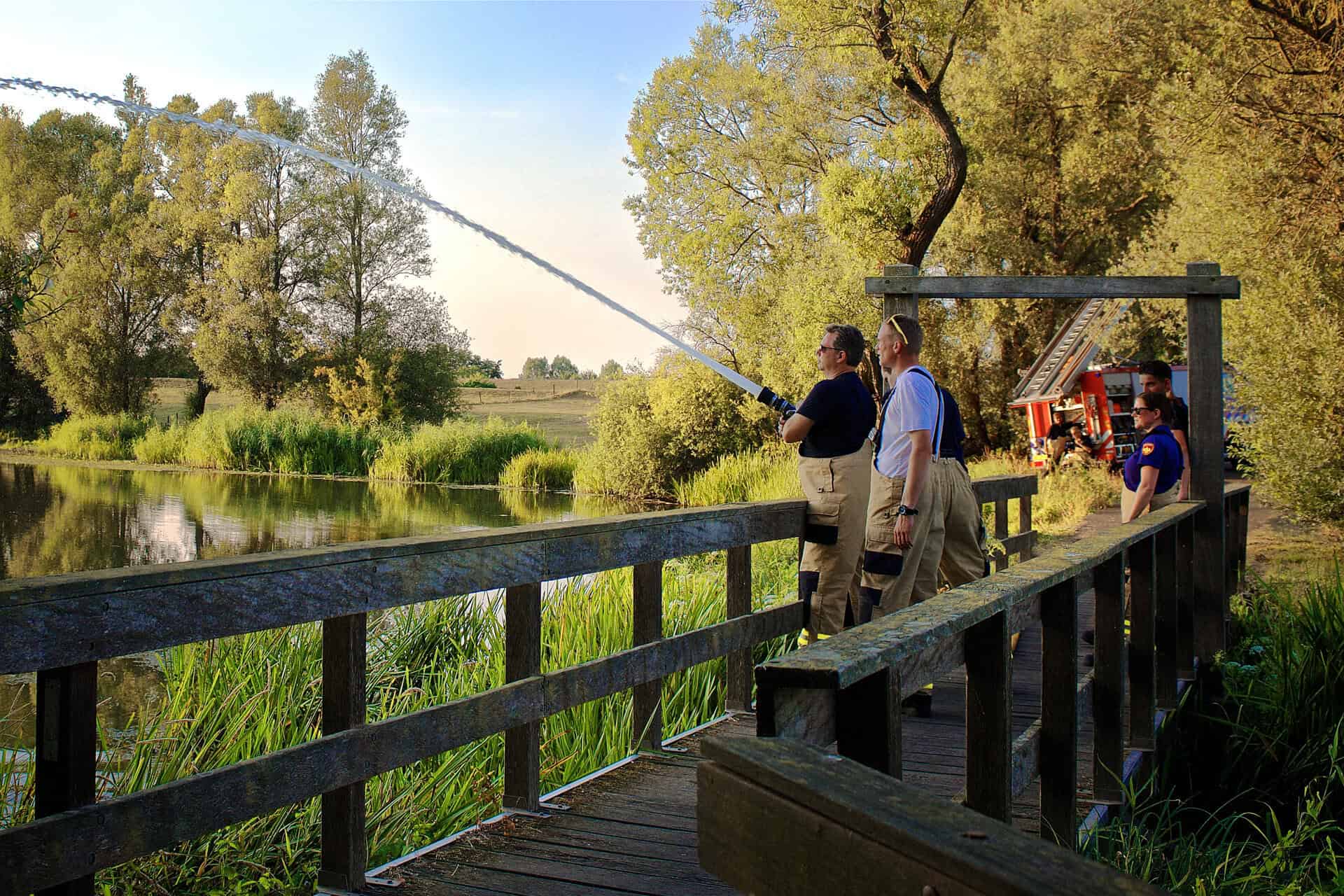Vissers op 't Gelders Eiland vangen vis vanaf de houten pier.