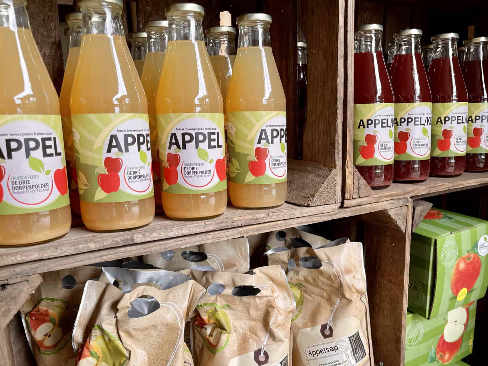 Flesjes appelsap en appelmoes op houten planken op 't Gelders Eiland.