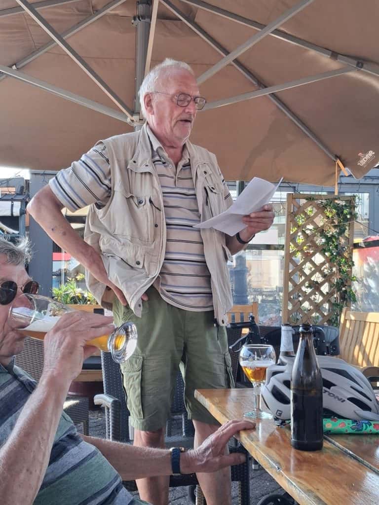 Man leest een speech voor tijdens een buitenbijeenkomst op 't Gelders Eiland.