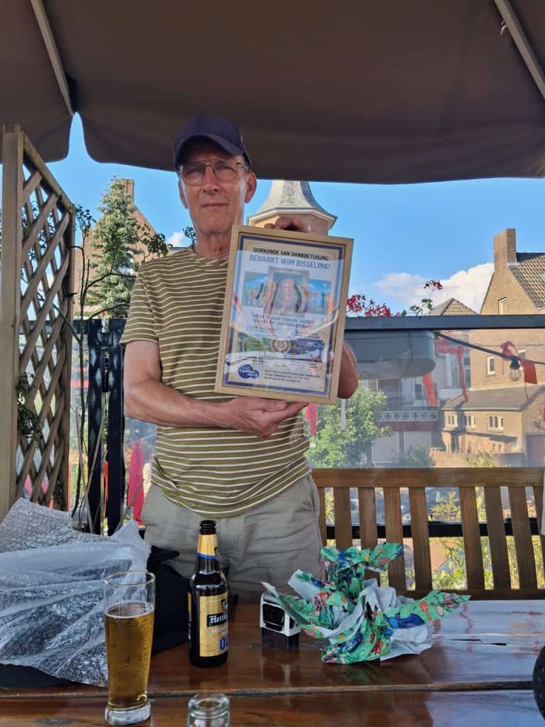 Man houdt certificaat vast tijdens buitenbijeenkomst op 't Gelders Eiland.