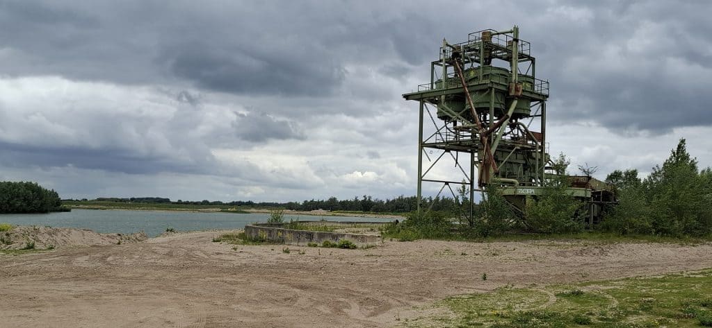 Verlaten industriële structuur op 't Gelders Eiland onder bewolkte hemel.