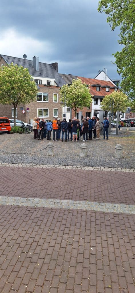 Groep mensen verzameld op 't Gelders Eiland onder bomen en overkapping.