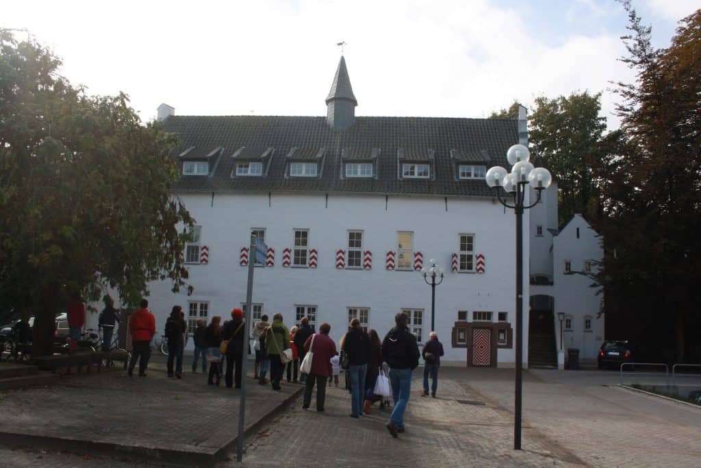 Historisch gebouw op 't Gelders Eiland met bezoekers voor de ingang.