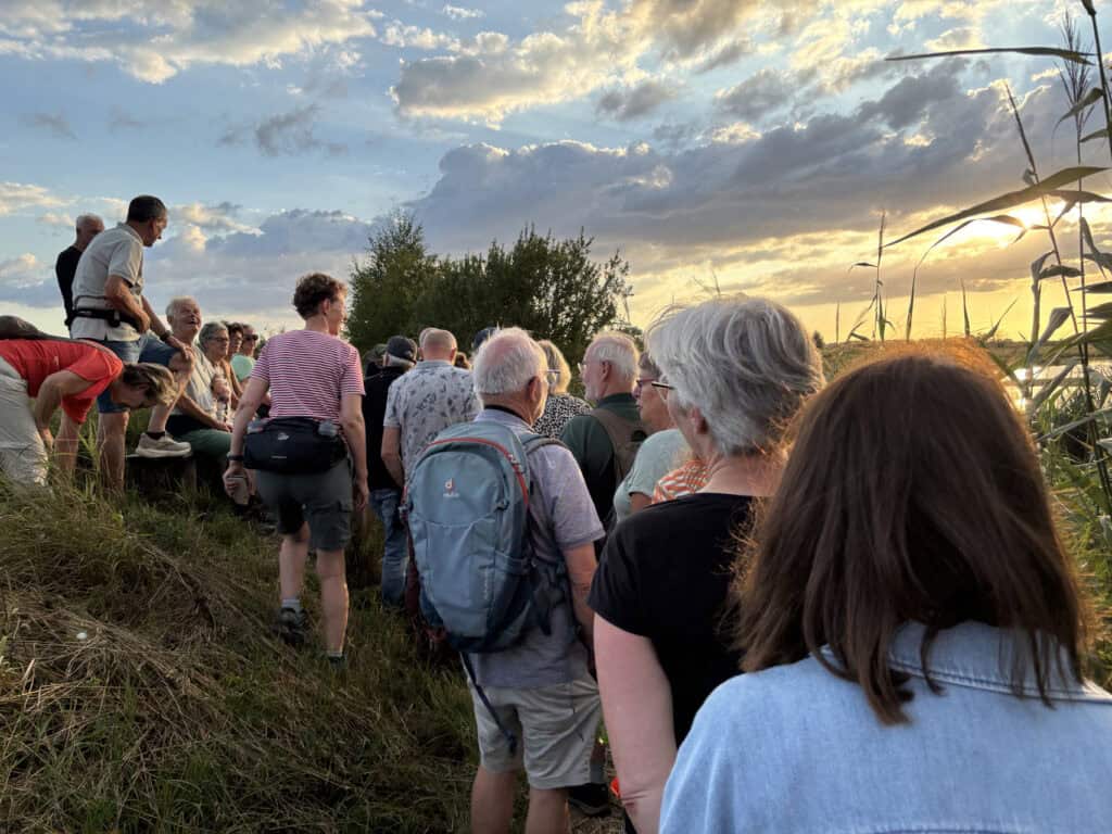 Groep mensen tijdens zonsondergang op 't Gelders Eiland.