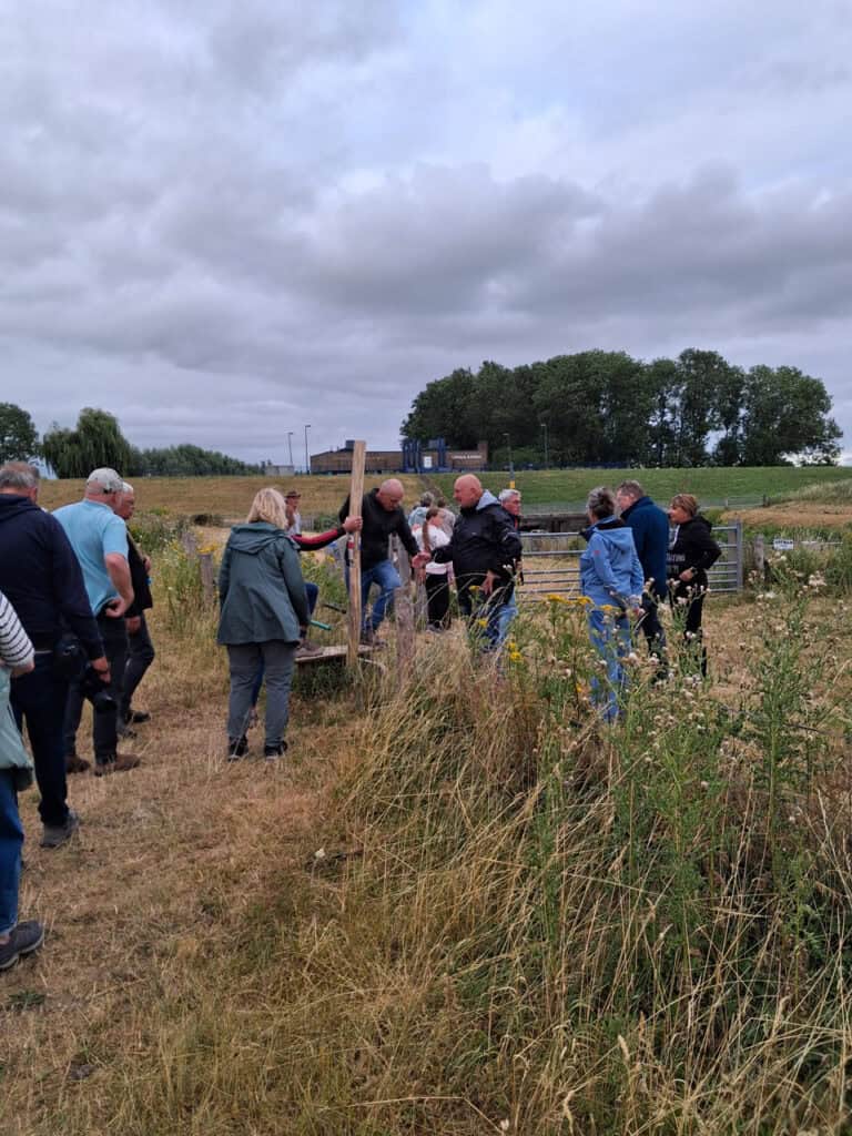 Groep mensen op 't Gelders Eiland tijdens een zomerse wandeling.