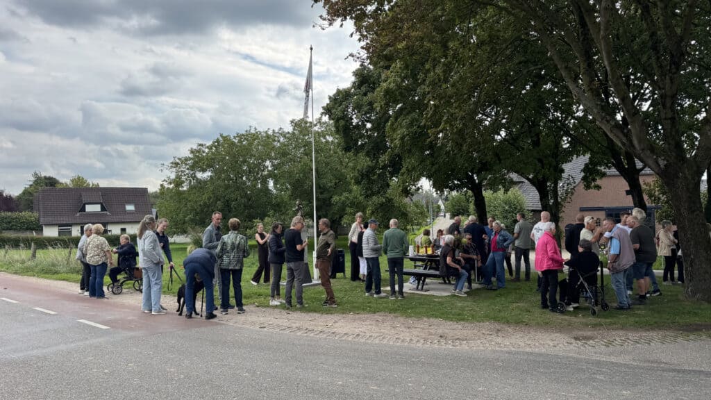 Mensen verzamelen zich bij de vlag op 't Gelders Eiland.